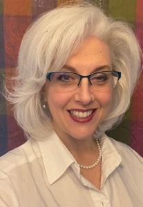 Woman with white hair and glasses.